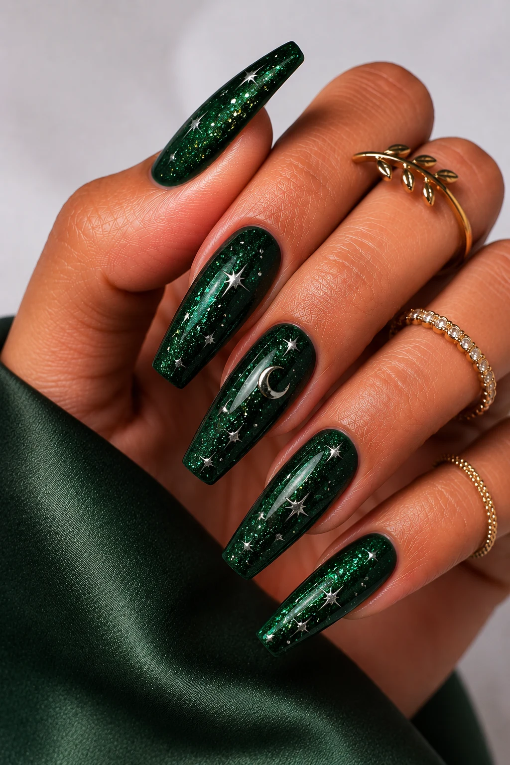 Glittering Emerald Galaxy Nails — green nail ideas acrylic style outfit, worn by a stylish woman
